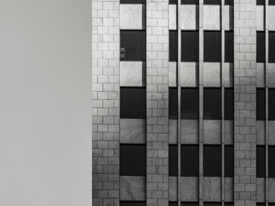 Minimalistische Steinfassade mit Fensterraster